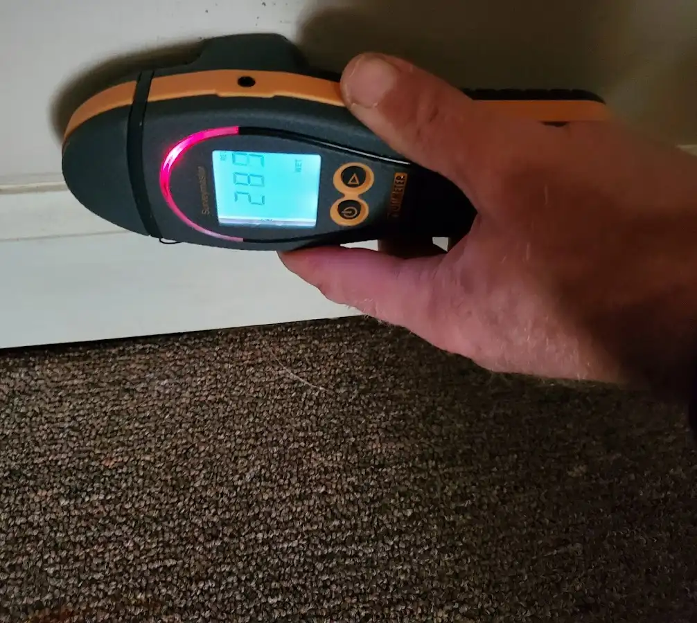 Moisture detection at baseboard during Storm Damage Restoration in Chain Lake